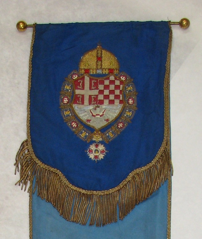 Trak za prapor z grbom kralja Jugoslavije, ki vsebuje v spodnjem polju modrega orla dežele Kranjske. Iz arhiva Muzeja in galerij mesta Ljubljane.