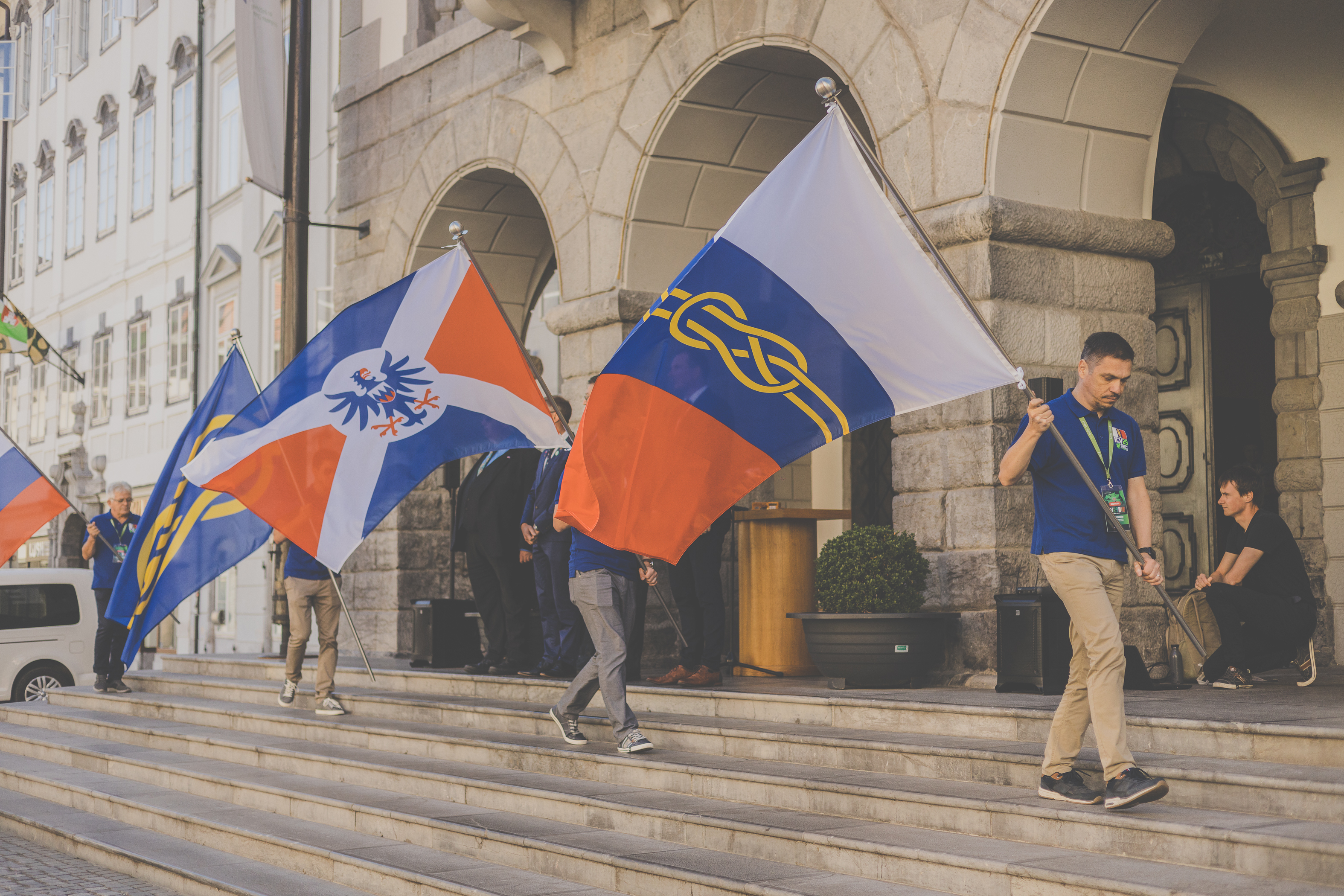 Slovesnost ob odprtju kongresa pred Mestno hišo v Ljubljani. Na fotografiji so zastave Slovenije, FIAV, Društva Heraldica Slovenica in zastava ICV 29. | 29. Mednarodni kongres zastavoslovja v Ljubljani, 11.7.2022. Foto: Simon Pelko.